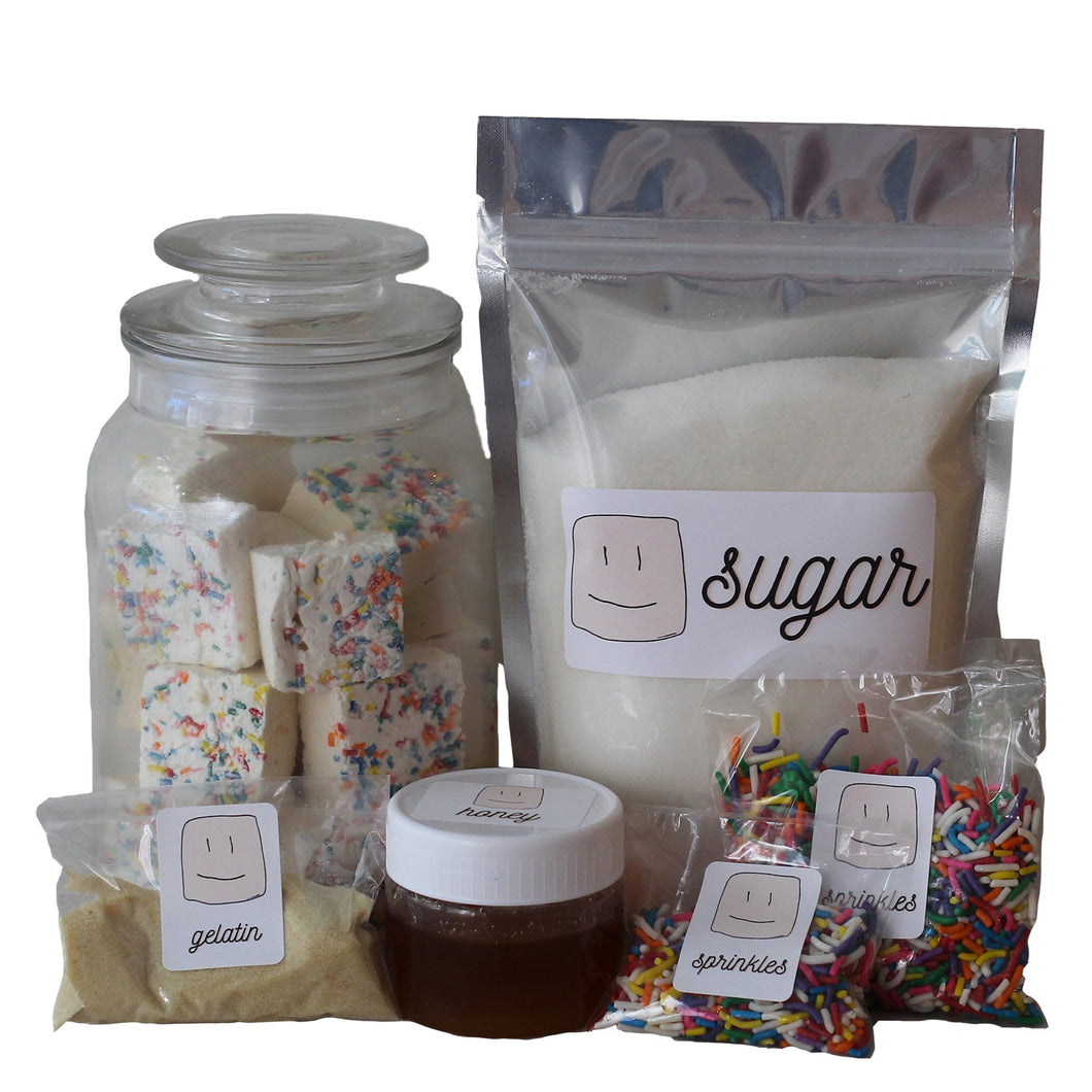ingredients in the marshmallow making kit, bag of sugar, jar of honey, packs of gelatin and sprinkles 