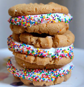 vanilla marshmallow fluff sandwiched in between peanut butter cookies with rainbow sprinkles 