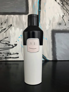 black and white water bottle with the squish logo face sticker on it, on a black countertop with a gray background