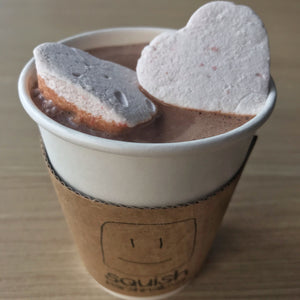 cup of hot chocolate with 2 marshmallow hearts inside